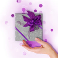 Woman hand and kraft gift box with pink bow on pink background decorated with confetti.. Top view, holiday present concept.